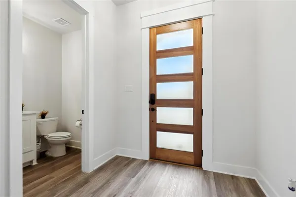 a bathroom view of a toilet and a hardwood floor