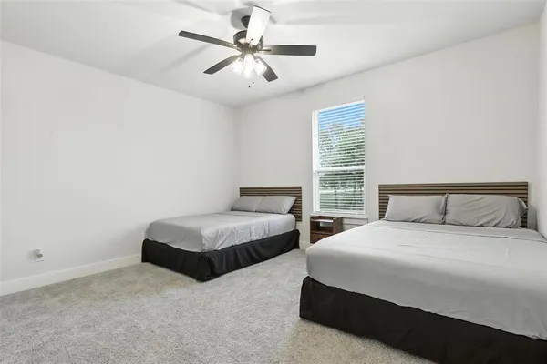 a spacious bedroom with two beds and a chandelier