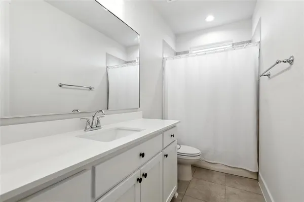 a bathroom with a sink a toilet a shower and a mirror