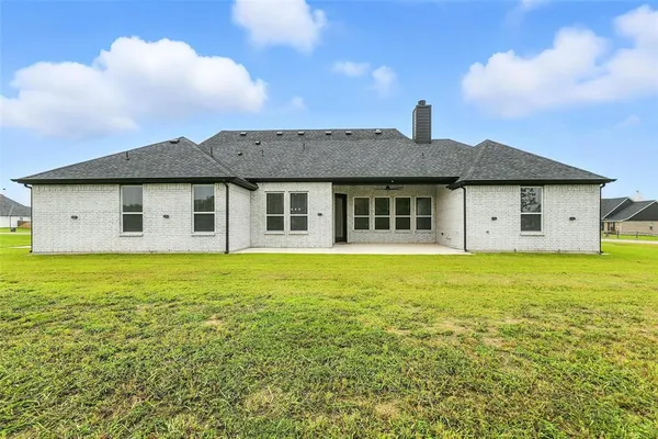 a view of a house with a yard balcony and a tree