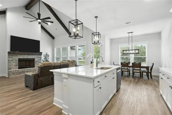 a open kitchen with a table chairs refrigerator and microwave