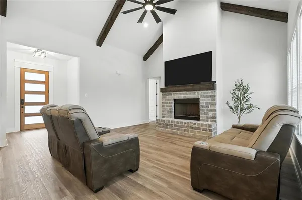 a living room with furniture a flat screen tv and a fireplace