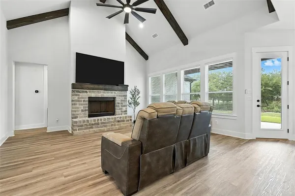 a living room with furniture a flat screen tv and a fireplace