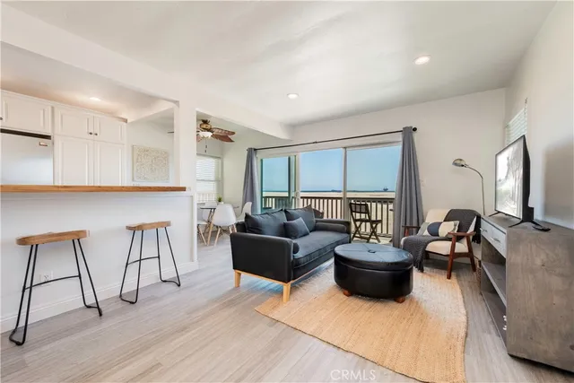 a living room with furniture a flat screen tv and a table