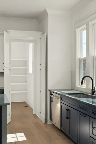 a kitchen with granite countertop a sink cabinets and stainless steel appliances