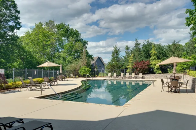 a view of a swimming pool with a table and chairs under an umbrella