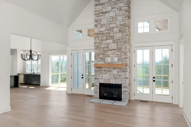 a view of empty room with fireplace and wooden floor