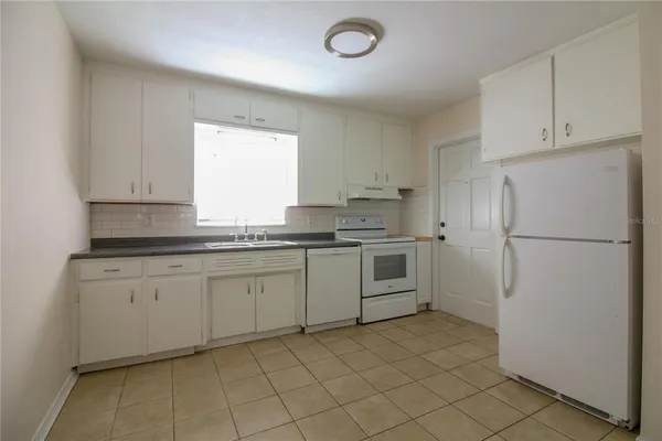 a kitchen with white cabinets and white appliances