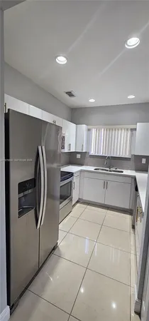 a kitchen with a refrigerator and a sink