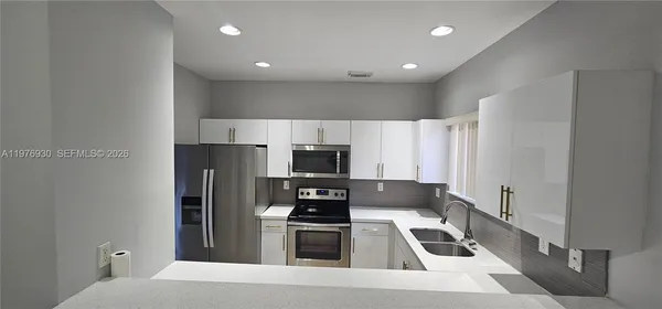 a kitchen with a sink cabinets and stainless steel appliances