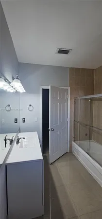 a bathroom with a double vanity sink mirror and shower