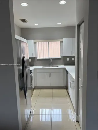 a kitchen with a sink a refrigerator and window