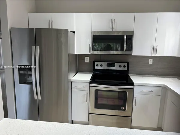 a kitchen with cabinets and stainless steel appliances