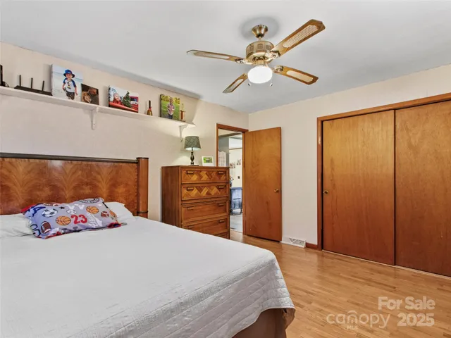 a bedroom with a large bed and a chandelier