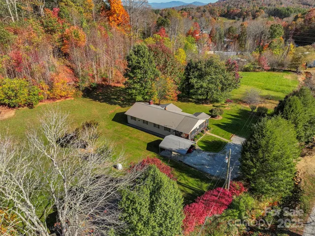 an aerial view of a house with a garden and lake view