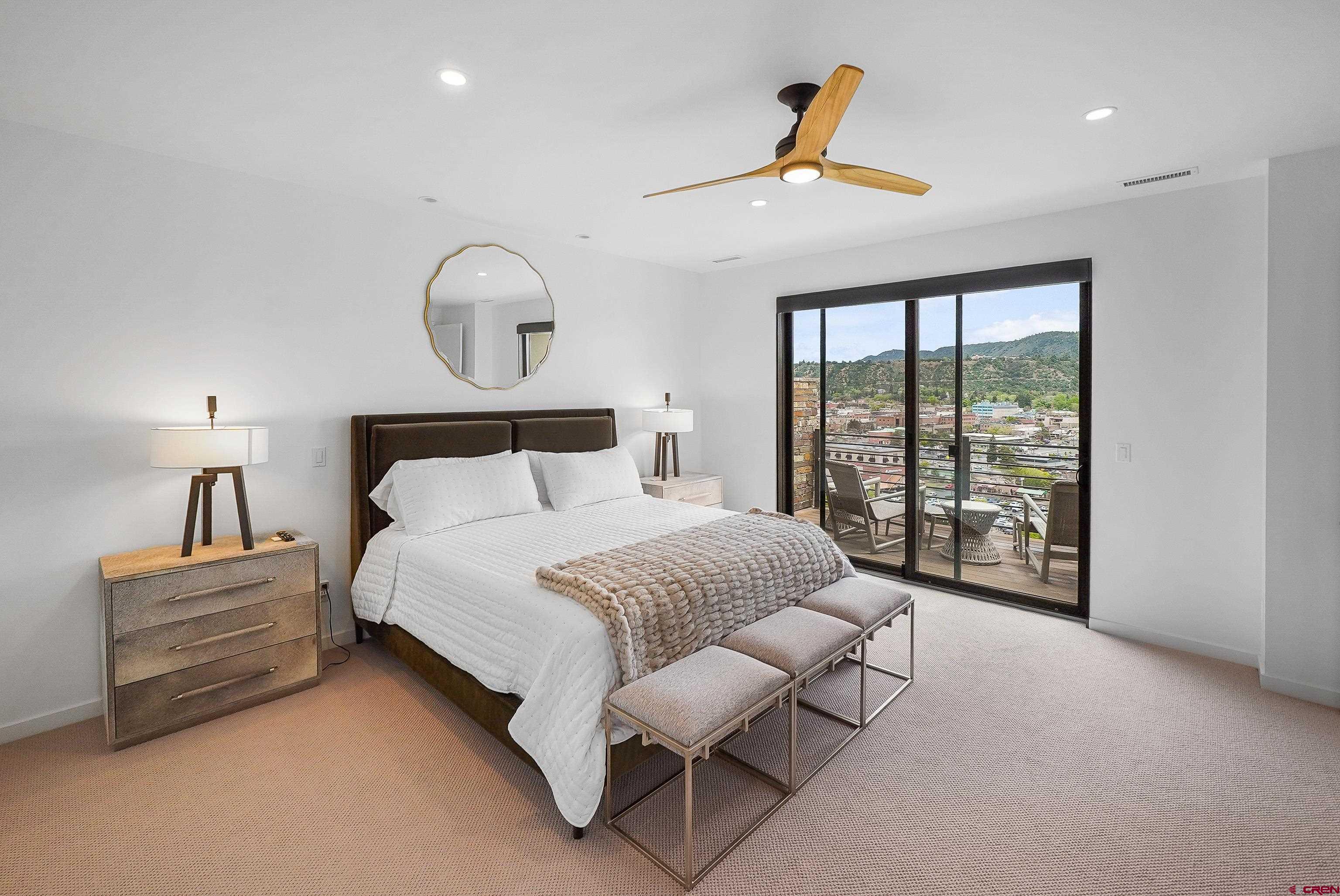 239 Rock Point Drive, Unit B Durango, CO 81301 - Photo 24 of 45 a spacious bedroom with a bed a couch and a window