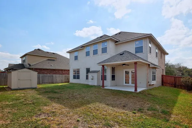 a view of a small house with wooden fence