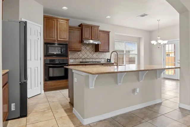 a kitchen with stainless steel appliances granite countertop a refrigerator and a sink