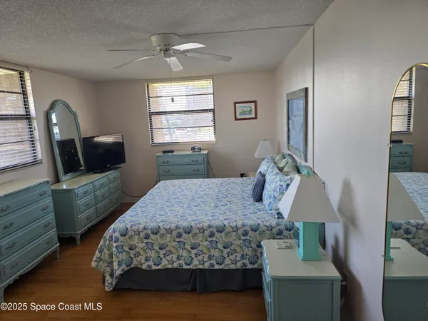a bedroom with a bed window with table and chair