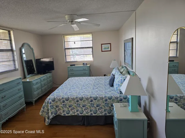 a bedroom with a bed window with table and chair