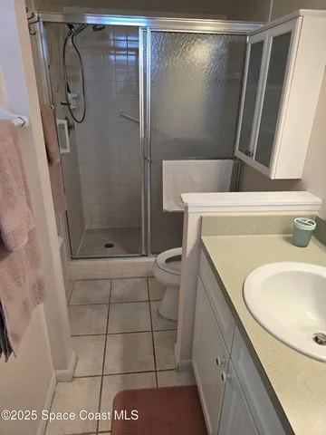 a bathroom with a granite countertop sink a toilet and shower