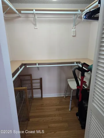 a view of walk in closet with clothes and shoes