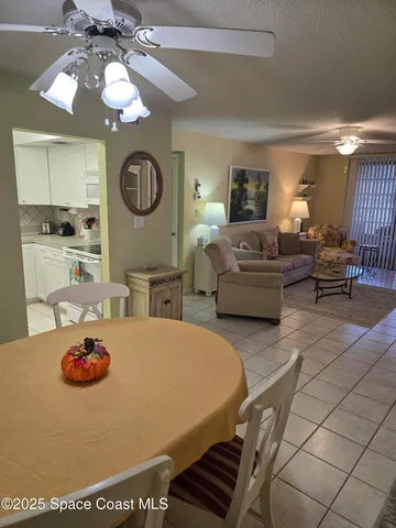 a living room with furniture a large window and a chandelier