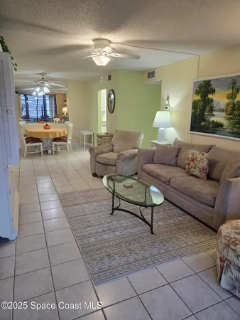a living room with furniture and view of kitchen