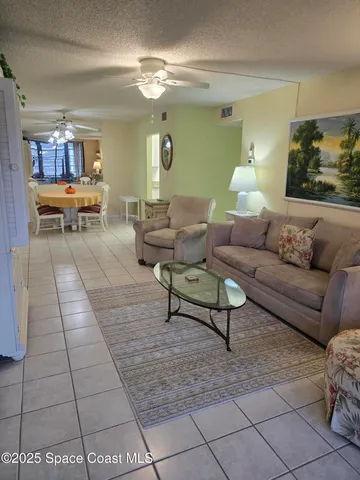 a living room with furniture and view of kitchen