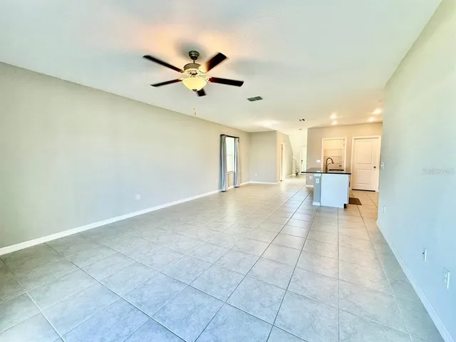 an empty room with a window and a fan