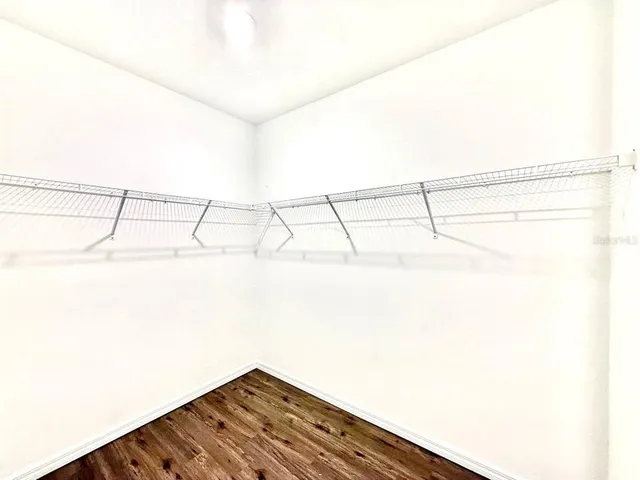 a view of a big room with a chandelier fan and windows