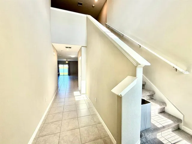 a view of a hallway with entryway and kitchen