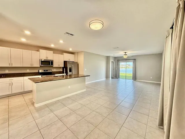 a view of kitchen with refrigerator and cabinets