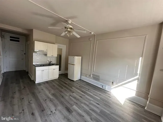 a kitchen with a refrigerator and a stove top oven