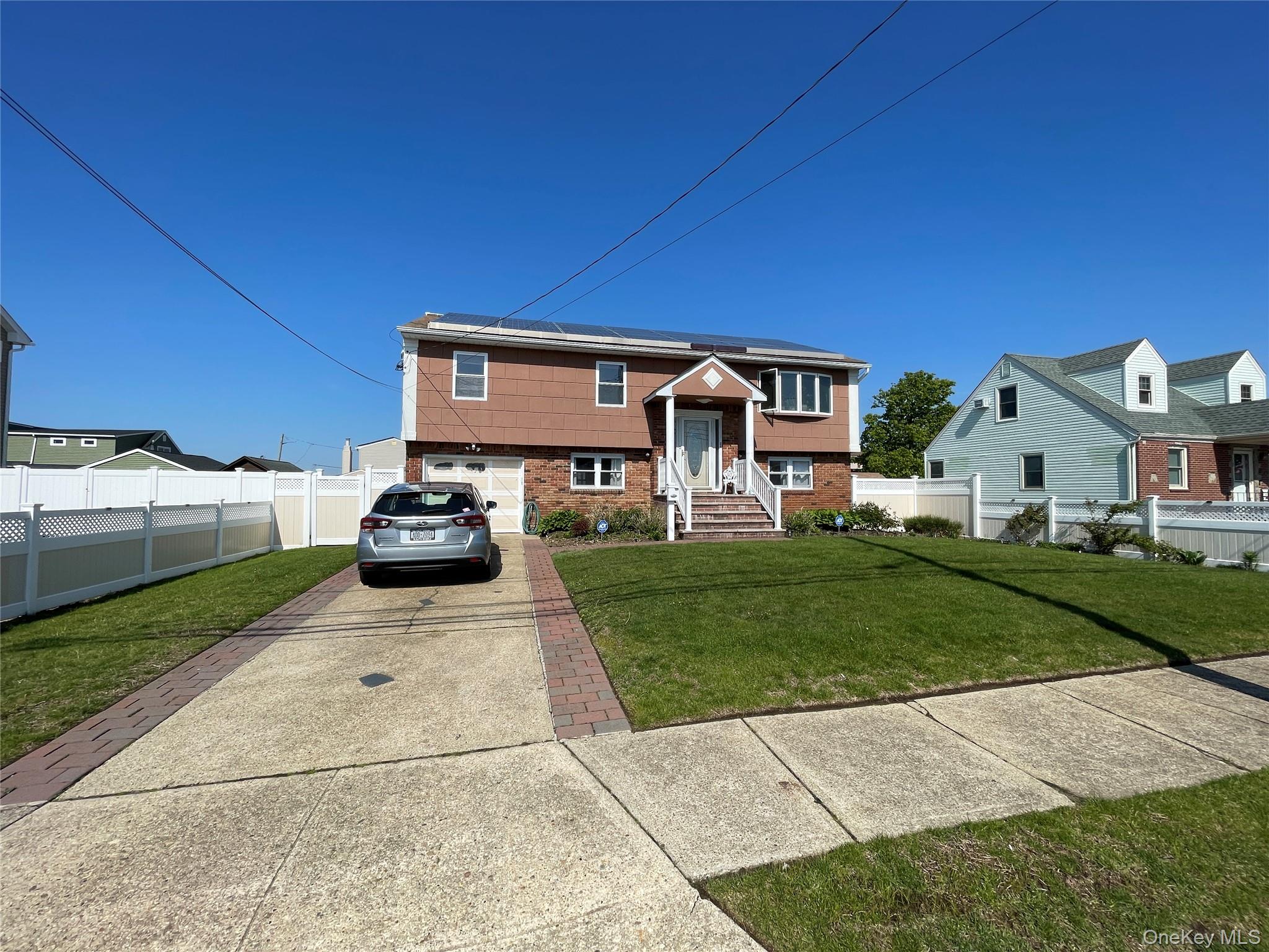 84 Surf Road Lindenhurst, NY 11757 - Photo 2 of 31 a car parked in front of a house with a yard