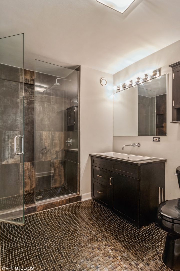 545 North Dearborn Street, Unit 1506 Chicago, IL 60654 - Photo 10 of 15 a bathroom with a sink and a mirror