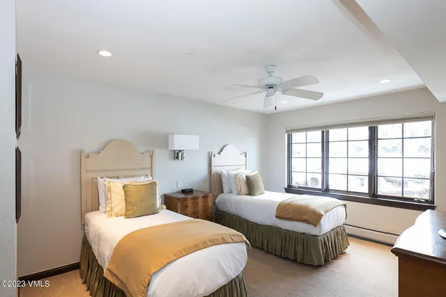 a bedroom with two beds and a large window