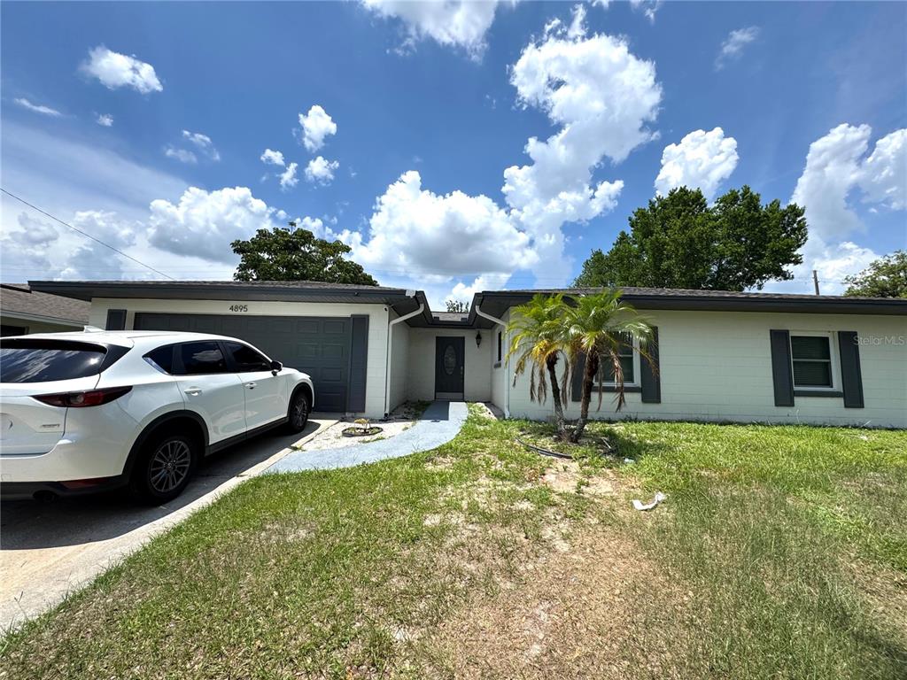 4895 East Wind Street, Unit 2 Orlando, FL 32812 - Photo 1 of 1 a front view of a house with garden