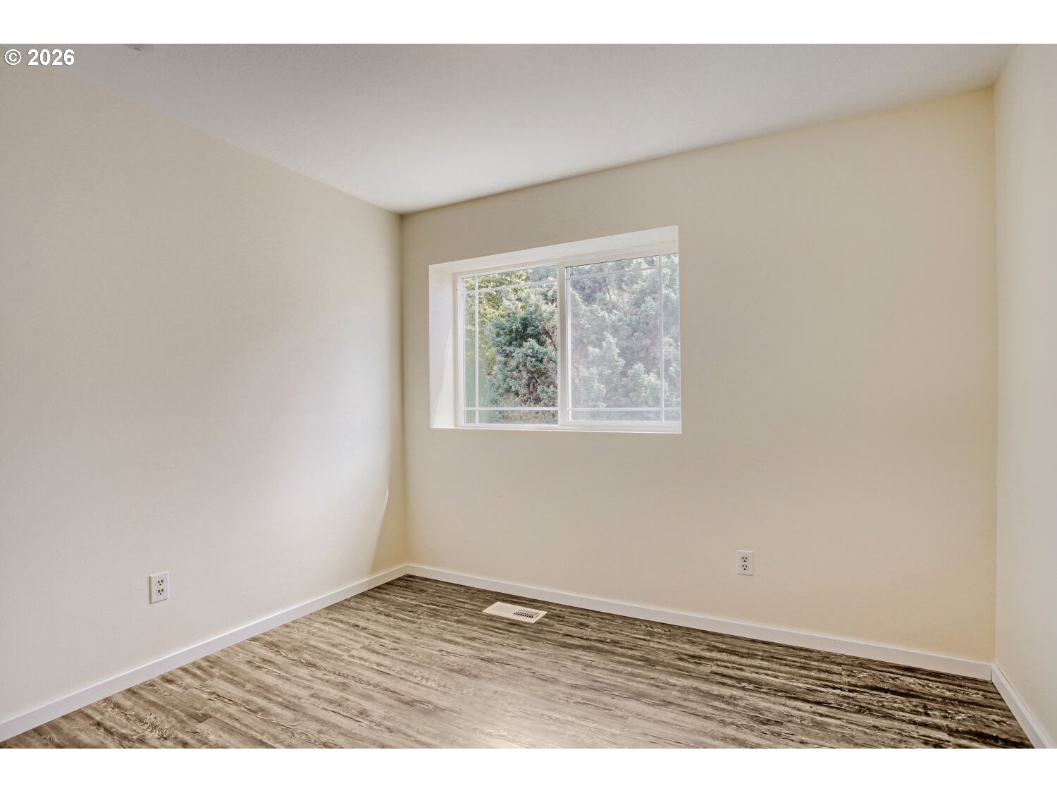 14539 Southeast Center Street Portland, OR 97236 - Photo 17 of 30 an empty room with wooden floor and painting on the wall