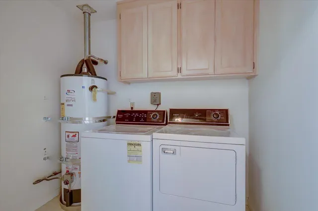 a room with a stove and white cabinets