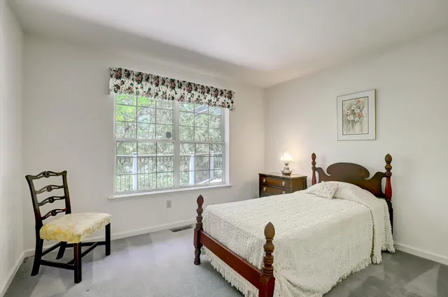 a bedroom with a bed chair and window