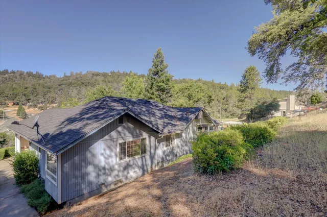 a view of a house with a yard and mountain in the background