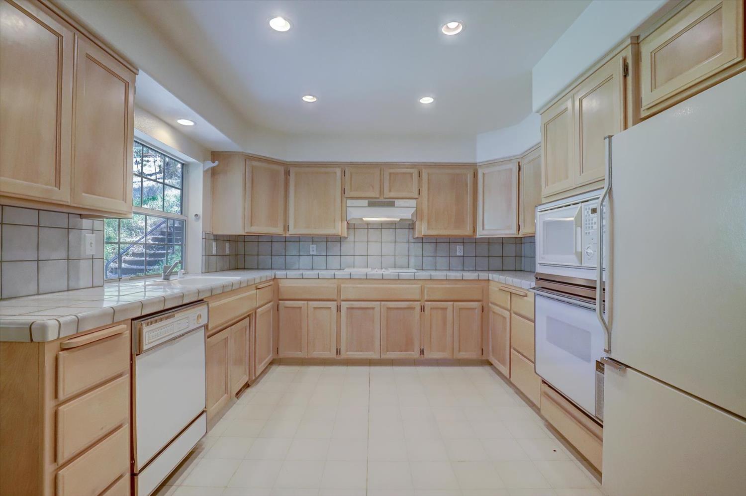 16479 Brewer Road Grass Valley, CA 95949 - Photo 9 of 33 a kitchen with granite countertop white cabinets and white appliances