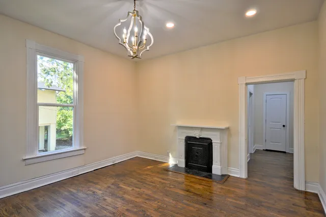a view of empty room with wooden floor and fireplace