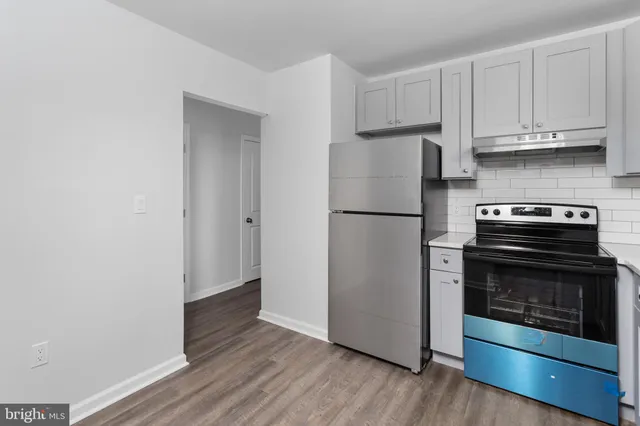 a kitchen with a refrigerator and a stove top oven
