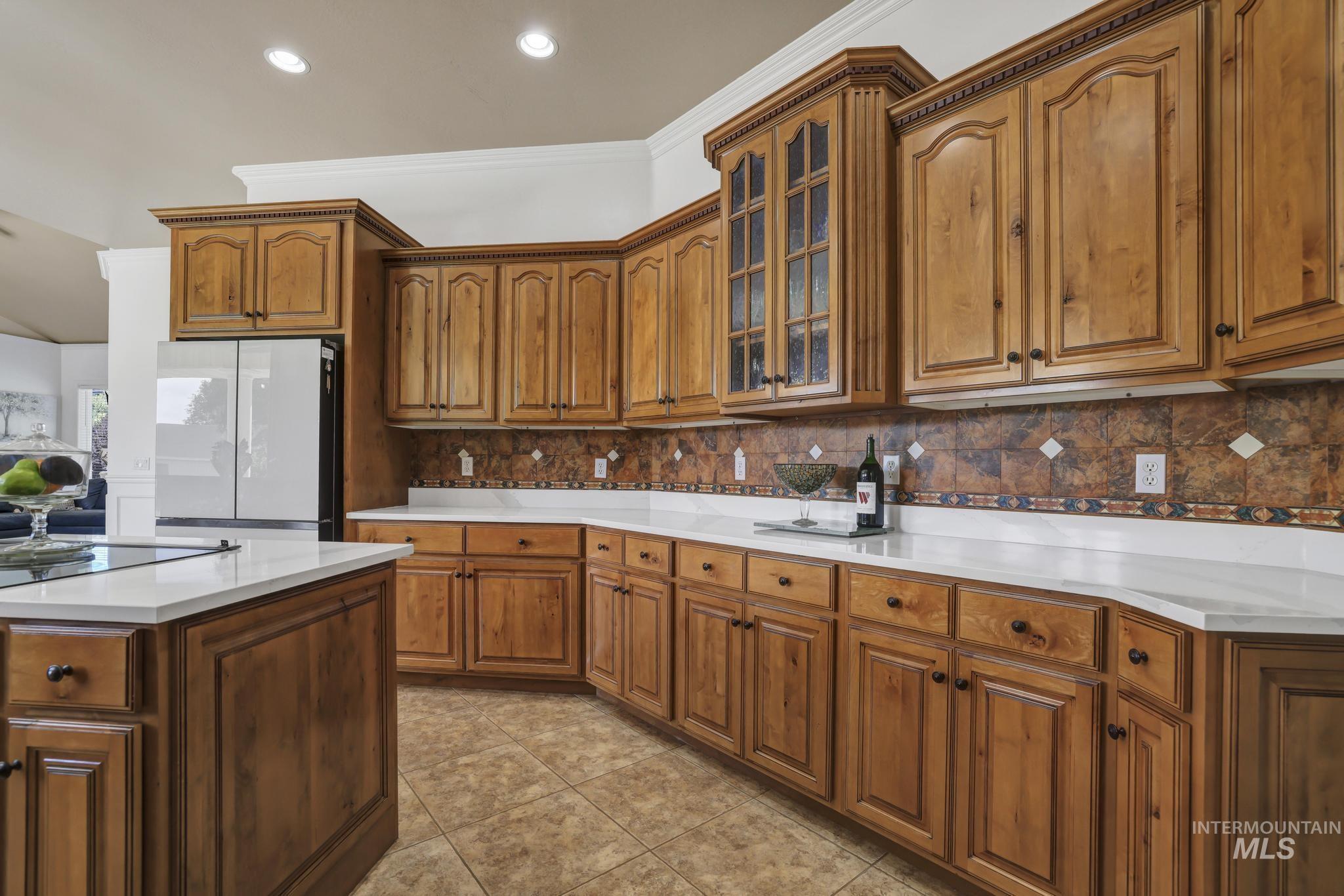1301 Kanaka Rapids Road Buhl, ID 83316 - Photo 25 of 50 Expansive kitchen featuring wood cabinetry, white countertops, a decorative tile backsplash, recessed lighting, and tile flooring