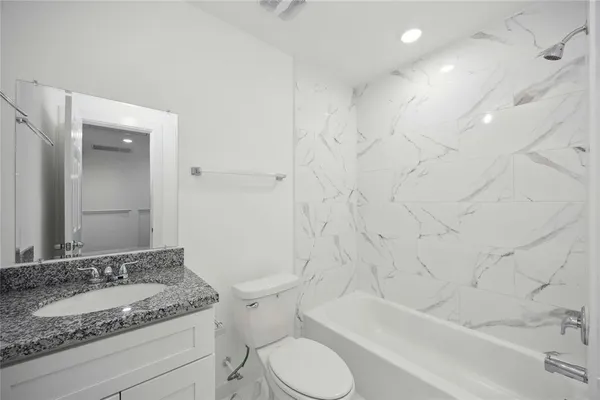 a bathroom with a granite countertop sink toilet and shower