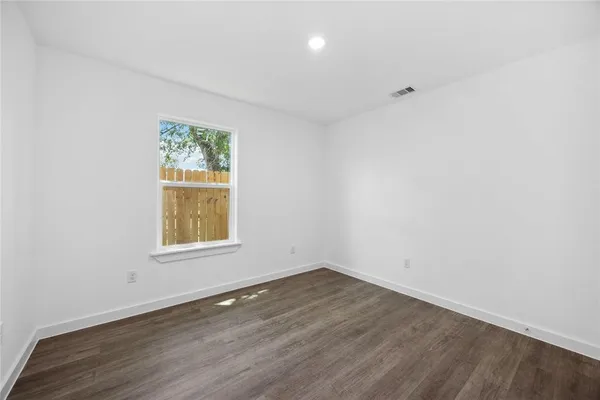 an empty room with wooden floor and a window