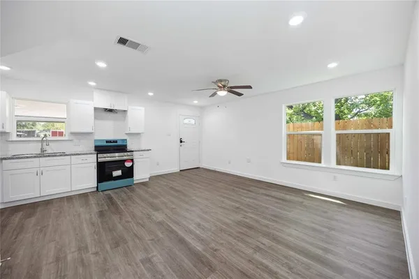 a kitchen with granite countertop a stove and a wooden floors