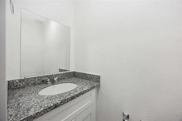 a bathroom with a granite countertop sink and vanity